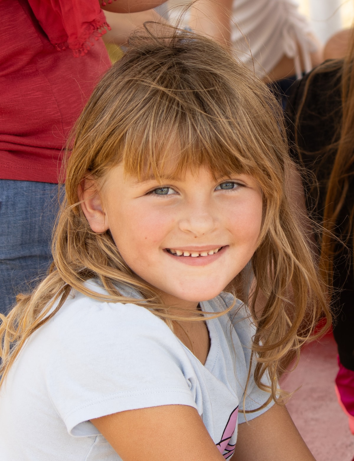Smiling blue-eyed child in a candid outdoor portrait